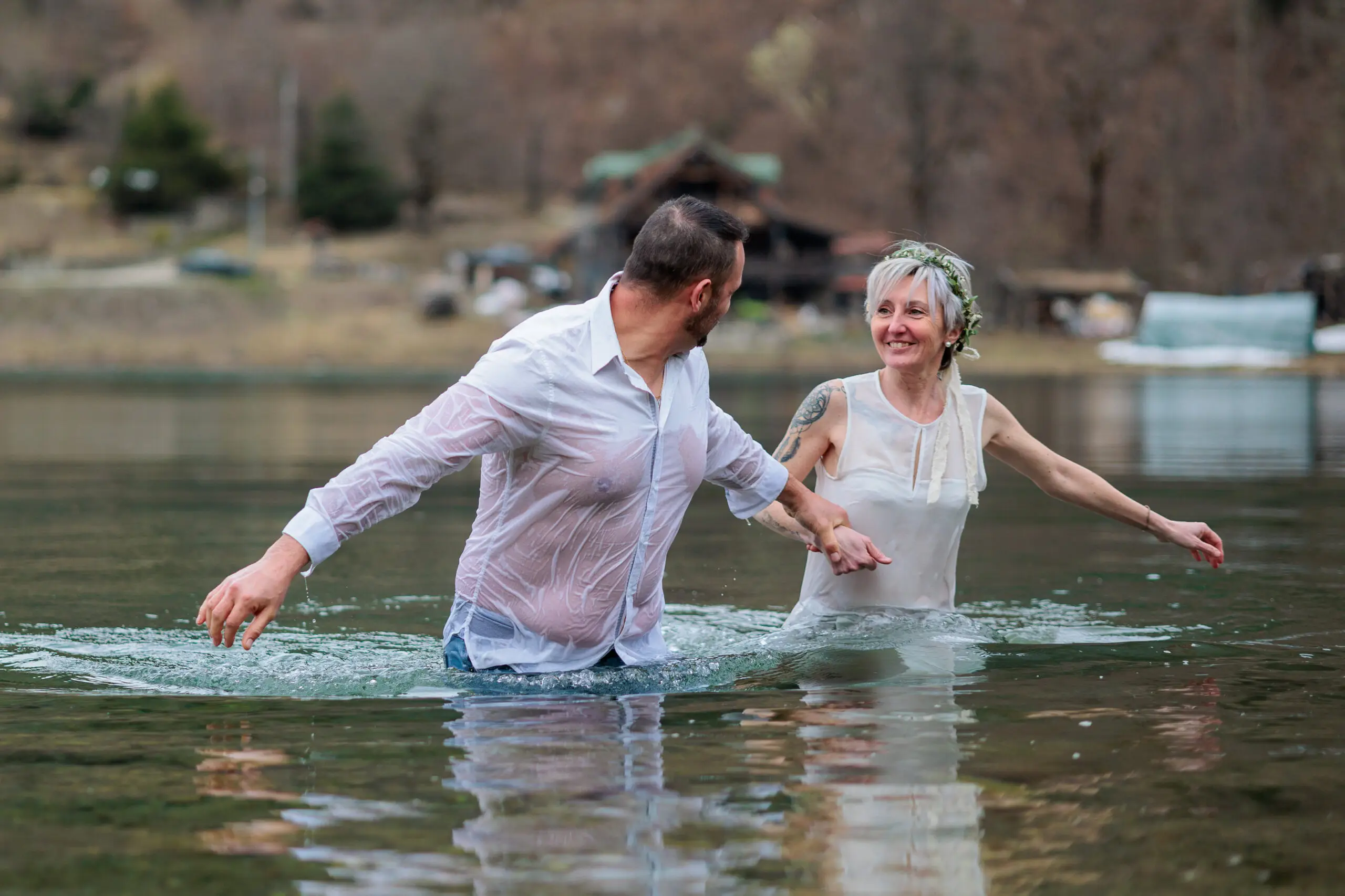 Couple plongeant habillés dans un lac en montagne